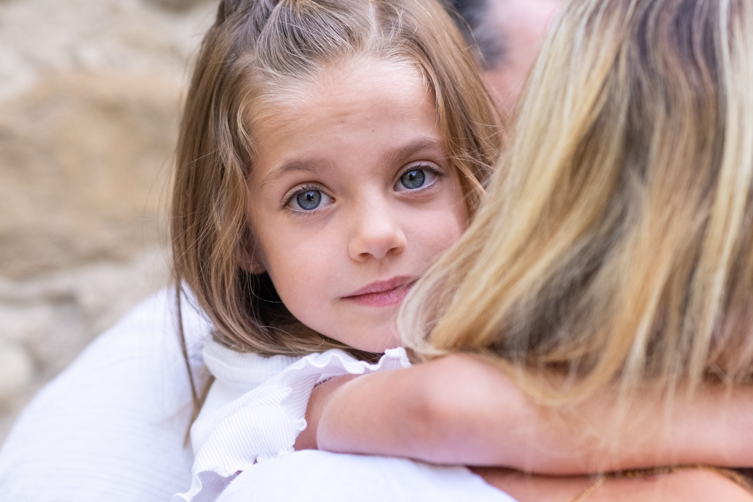 portrait d'une petite fille aux yeux clairs dans les bras de sa maman