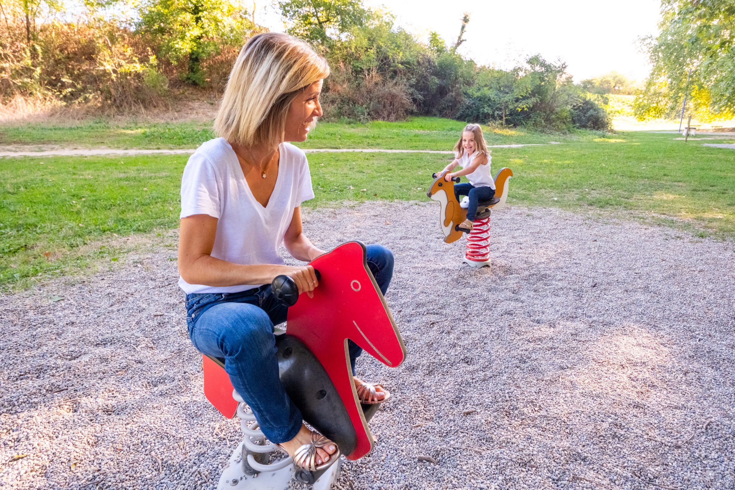 maman et sa fille sur les jeux à ressort d'une aire de jeux, séance photo famille dans la Drôme